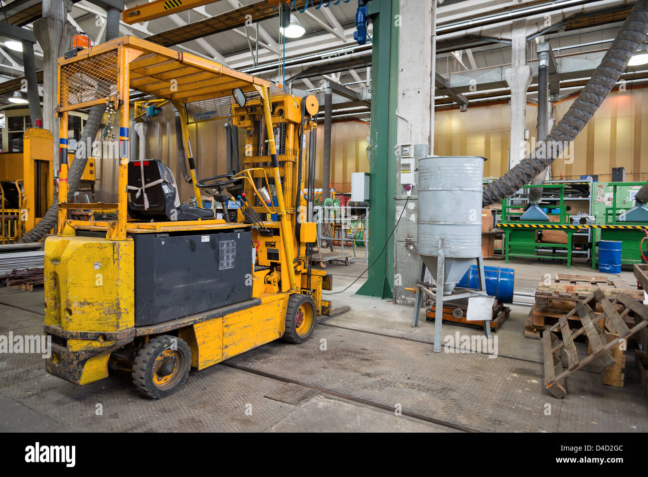 interior of workshop with yellow forklift and tools Stock Photo