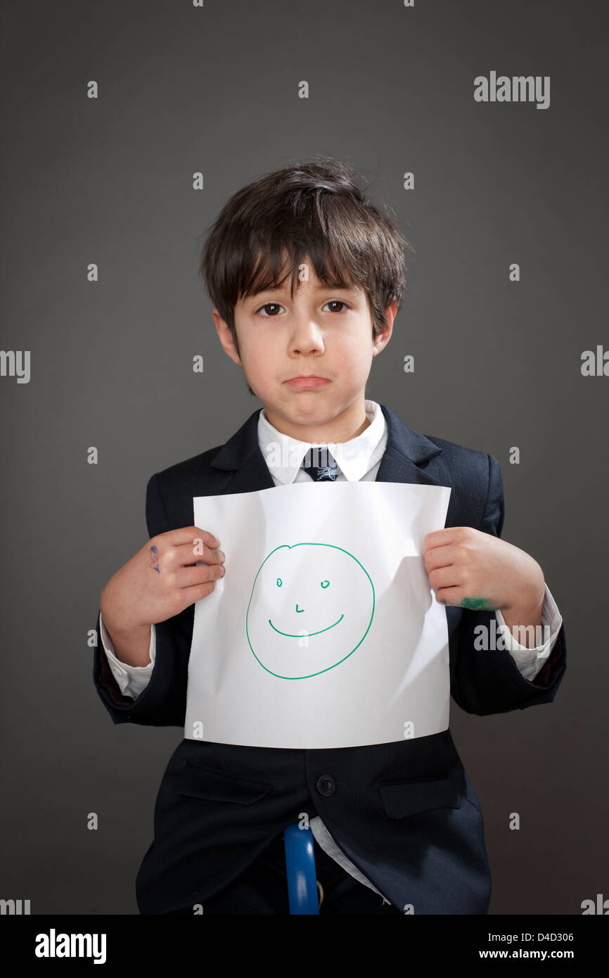 Sad boy with drawing of happy face Stock Photo