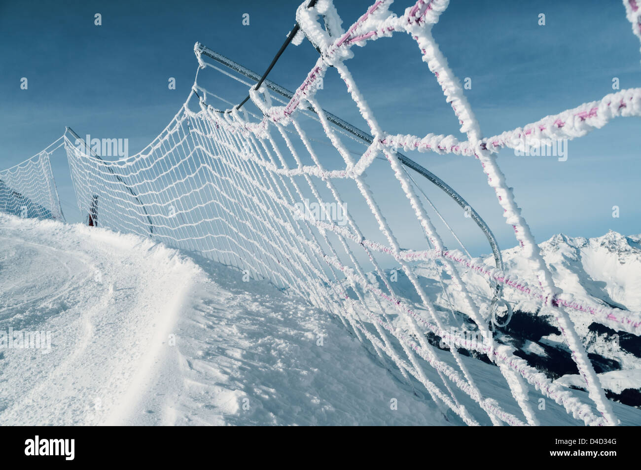 frozen and snow covered protective net on skiing track, italian alps Stock Photo