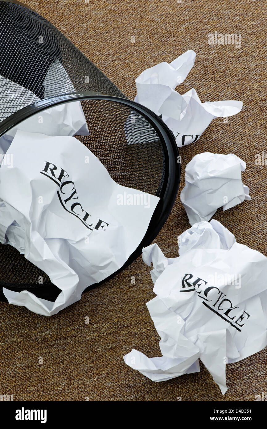 Waste paper basket with crumpled paper and the word 'recycle' Stock