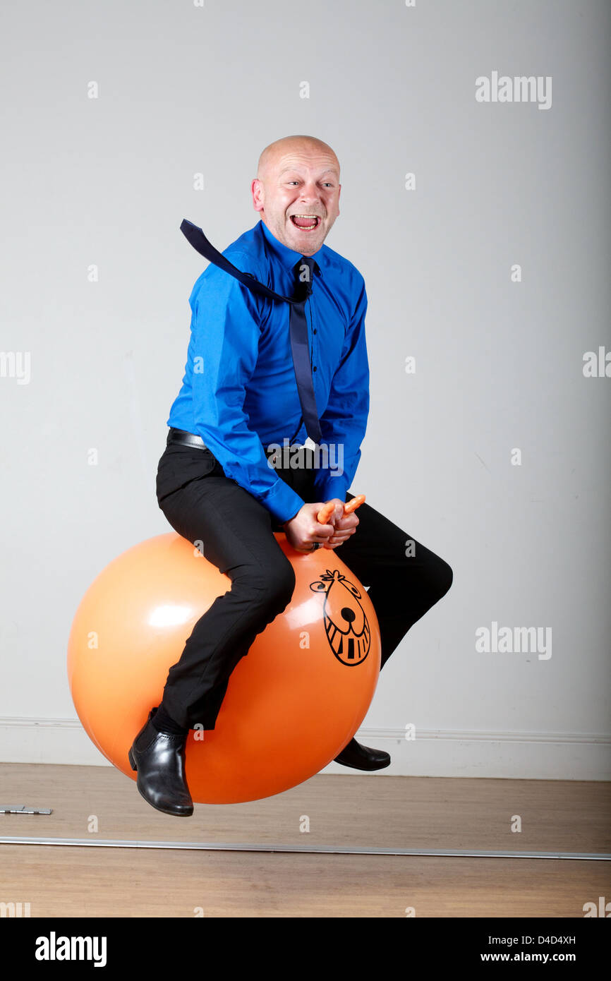 business man on space hopper Thursday 12th May Stock Photo