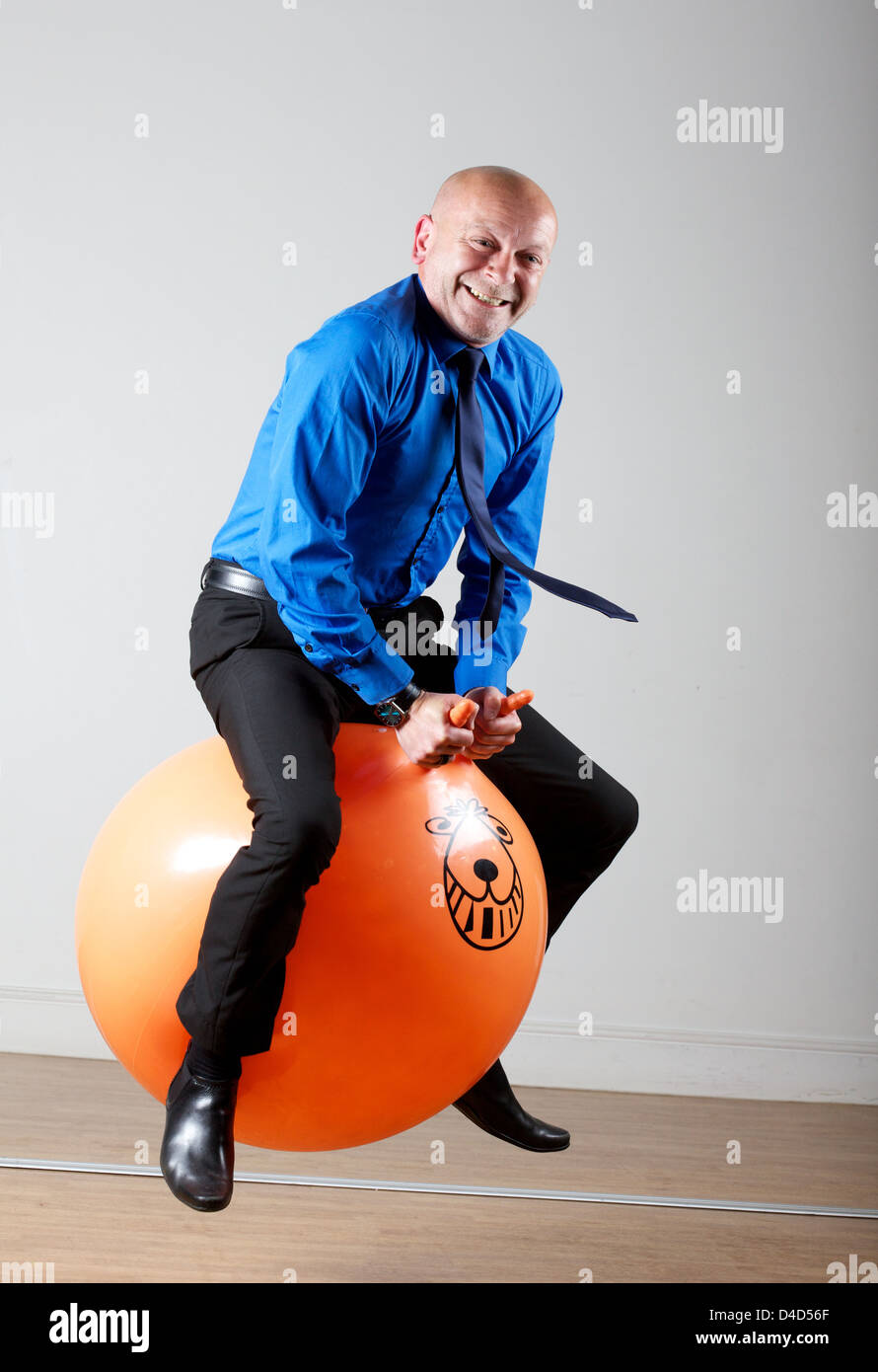 Business man on space hopper  Thursday 12th May Stock Photo