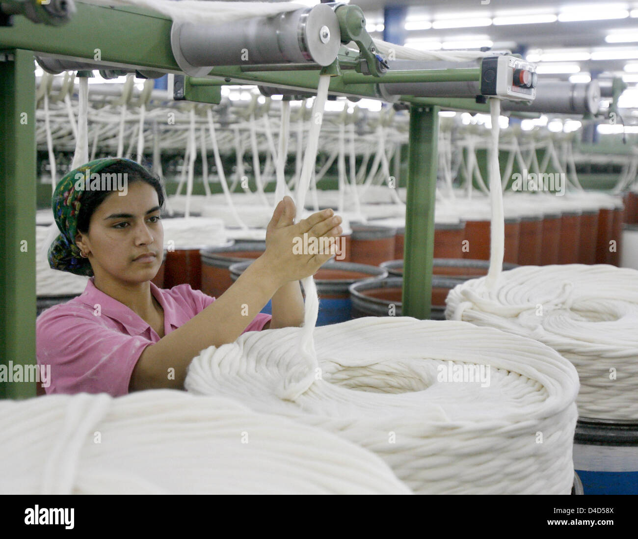 The picture shows a member of staff in a cotton spinning mill in ...