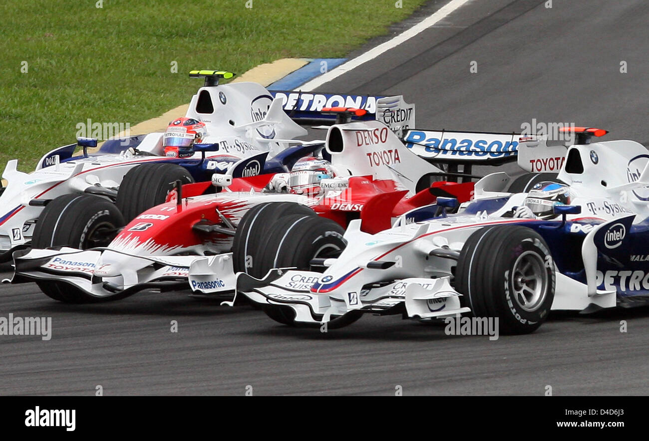 German Formula One driver Timo Glock of Toyota F1 (C) is sandwiched by BMW  Sauber's Polish Robert Kubica (L) and German Nick Heidfeld (R) in the 2008  Formula 1 Malaysian Grand Prix