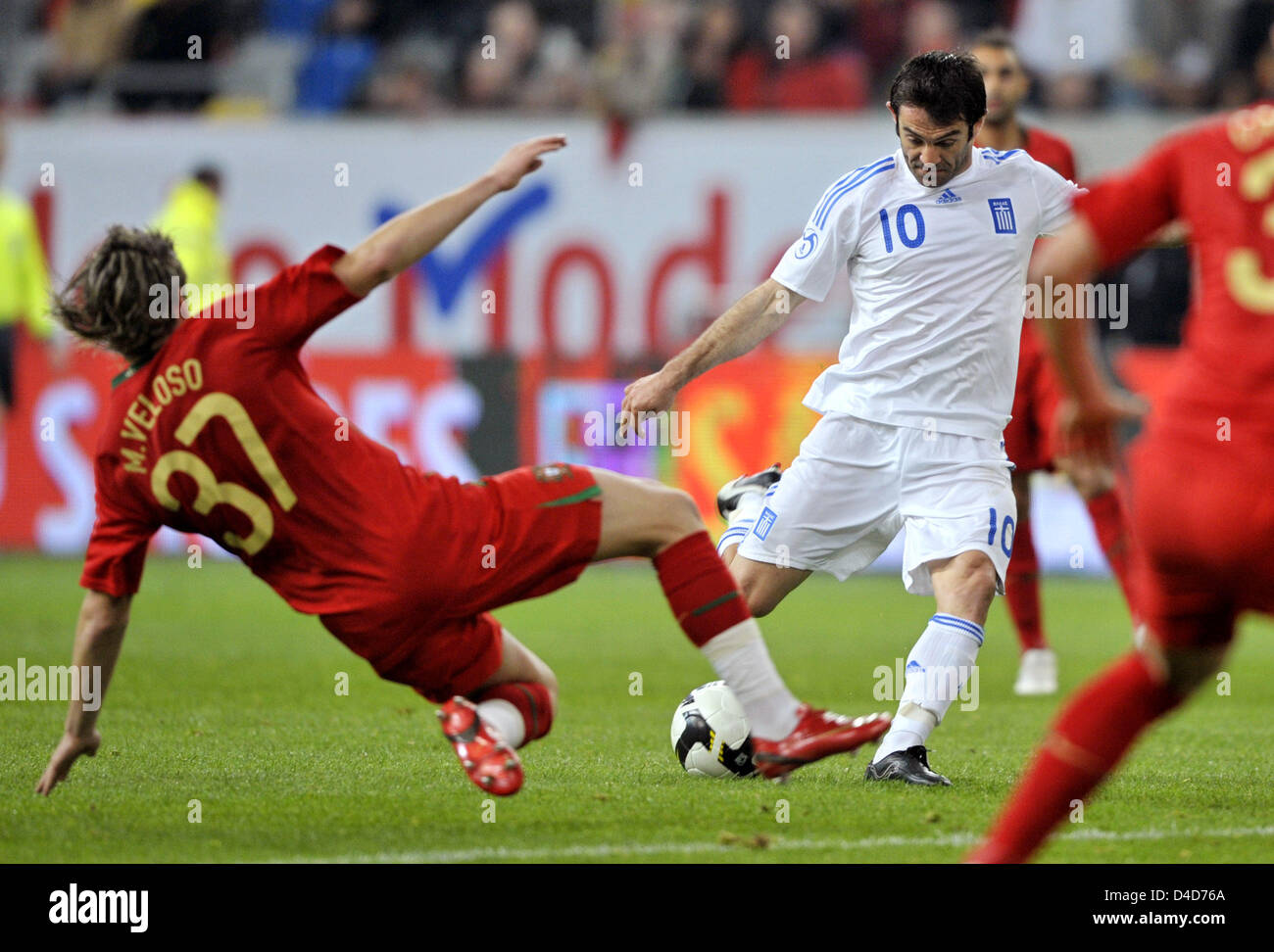Miguel Veloso of Portugal (L) throws himself into the shot fired by Greek Georgios Karagounis (C) in the test cap Portugal v Greece at LTU Arena stadium in Duesseldorf, Germany, 26 March 2008. Greece defeated Portugal 2-1. Photo: Achim Scheidemann Stock Photo