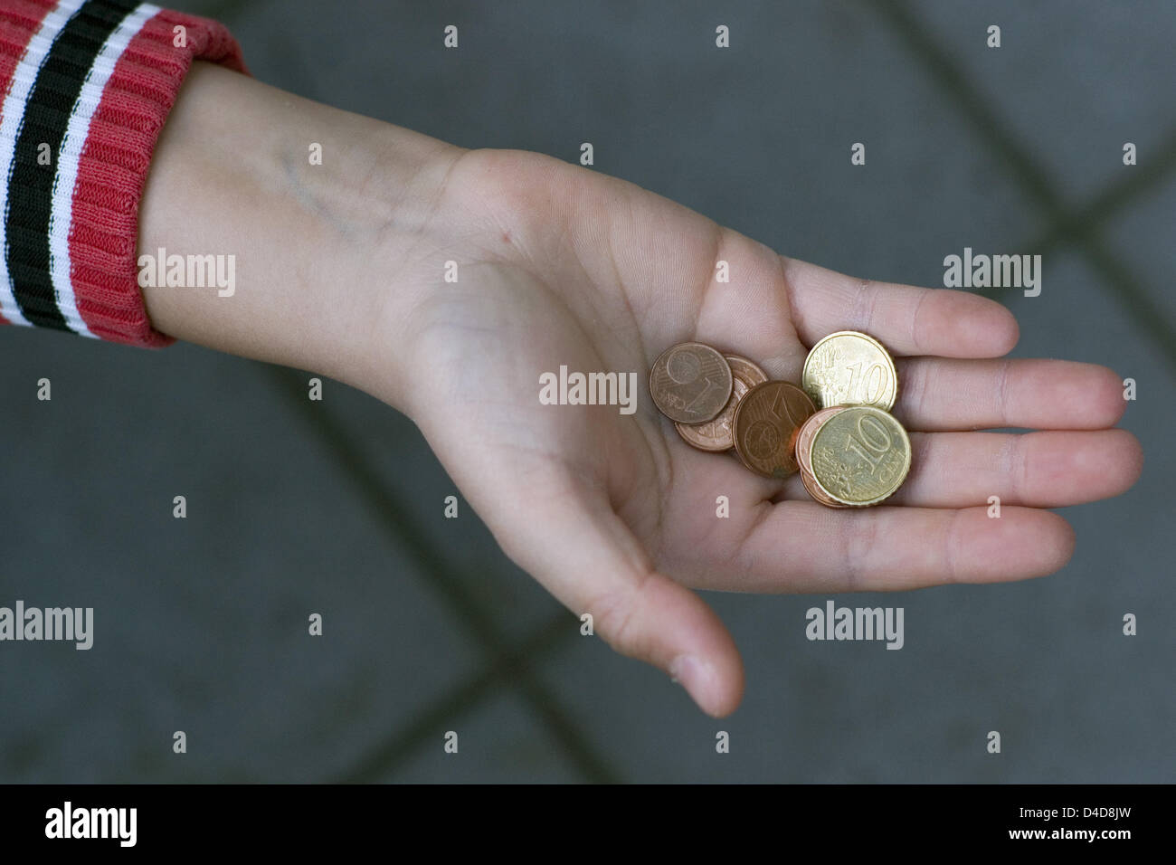 A 10-year-old shows a few cents in a backyard in Hamburg, Germany, 21 March 2008. AQccording to a study conducted by the Paritaetische an association of social movements 1.5 million children in Germany live on social security level. The estimate of children qualifying for social security but not receiving any is 200,000. 14.2 percent of the children in Germany live in povery - that Stock Photo