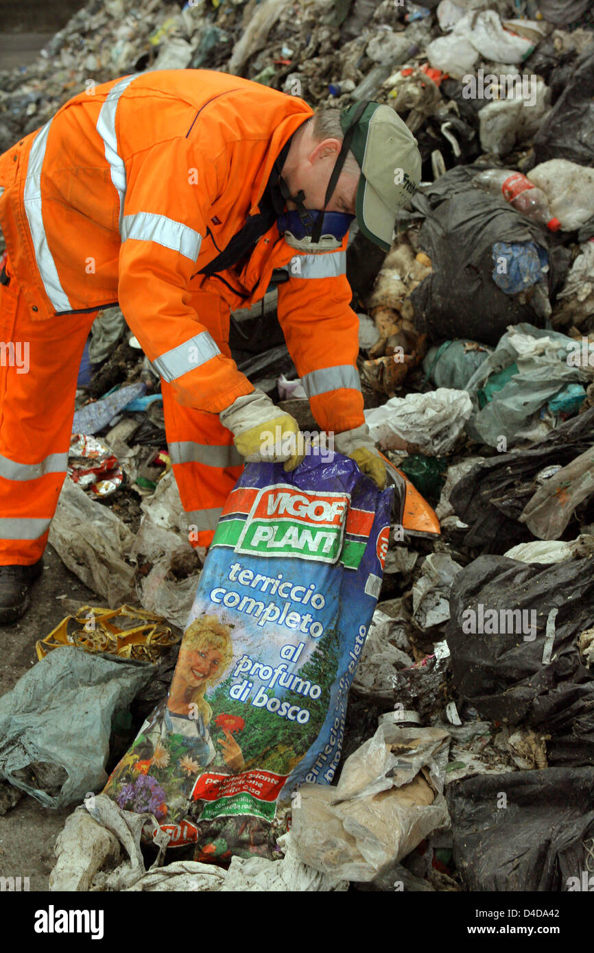 A worker examines waste from Naples at the premises of waste management company Abfallwirtschaft Westsachsen in Croebern near Leipzig, Germany, 08 April 2008. After a suspension of waste imports from southern Italy in the coming weeks some 35,00  t instead of the approved 100,000 are expected to be disposed off at the facility in Croebern until the permit runs out on 20 May 2008. T Stock Photo