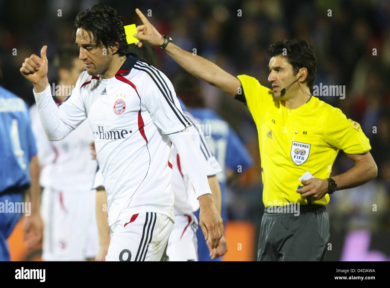 Referee Massimo Busacca (R) shows Munich's Luca Toni the yellow card during  second leg UEFA Cup quarter finals soccer match Getafe CF vs. Bayern Munich  at Coliseum Alfonso Perez stadium, in Getafe,