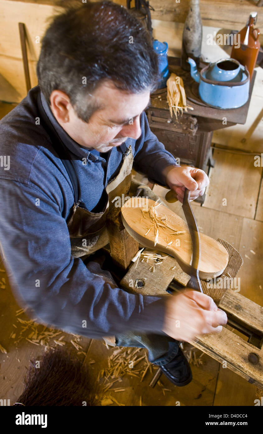Clogs manufacturer Manfred Karolczak works a piece of lumber in his