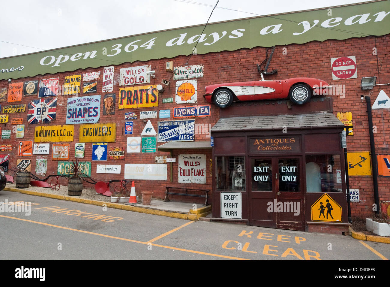 Collection of old metal signs displayed on the wall of an former Lancashire cotton mill now used as an antiques centre. Stock Photo