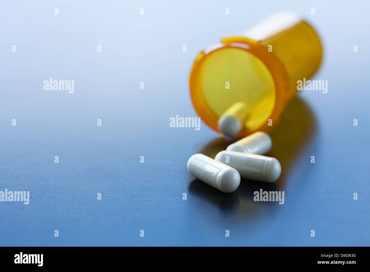 Capsules spilled from pill bottle Stock Photo