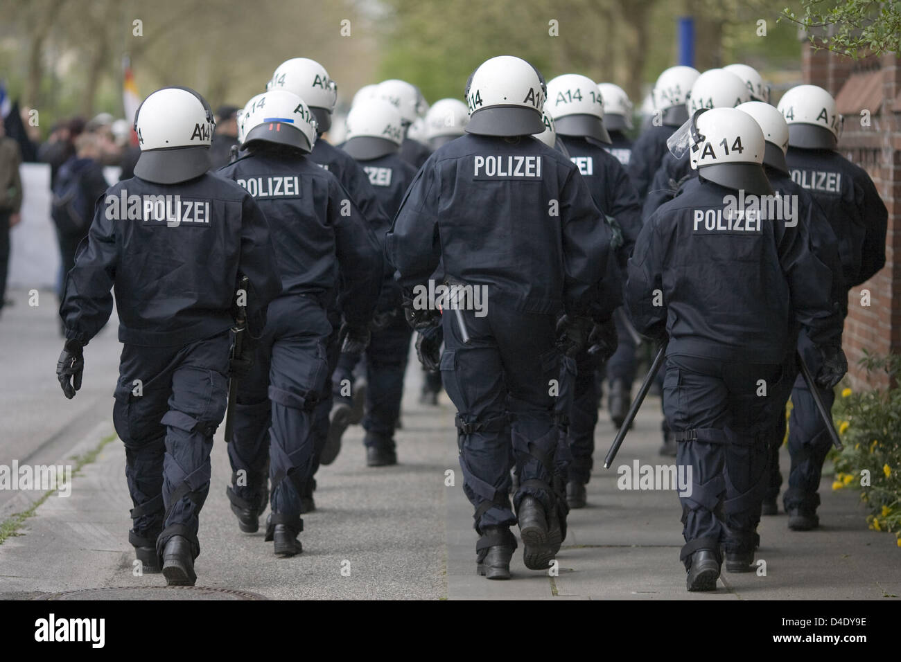 Riot police in protective clothing shown in action from behind during a ...