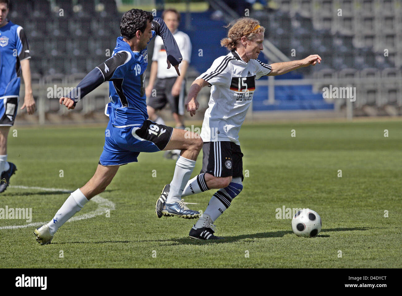 Klaus Doering of Germany (R) defends the ball against Isarel's Avi Shilon during a so-called 'Writers League' match at Wurfplatz stadium in Berlin, Germany, 06 May 2008. German and Israeli writers met for a match on invitation of the German Foreign Office and the German Football Federation (DFB) culture foundation. The newly found 'Writers League' aims to contribute to the nations' Stock Photo