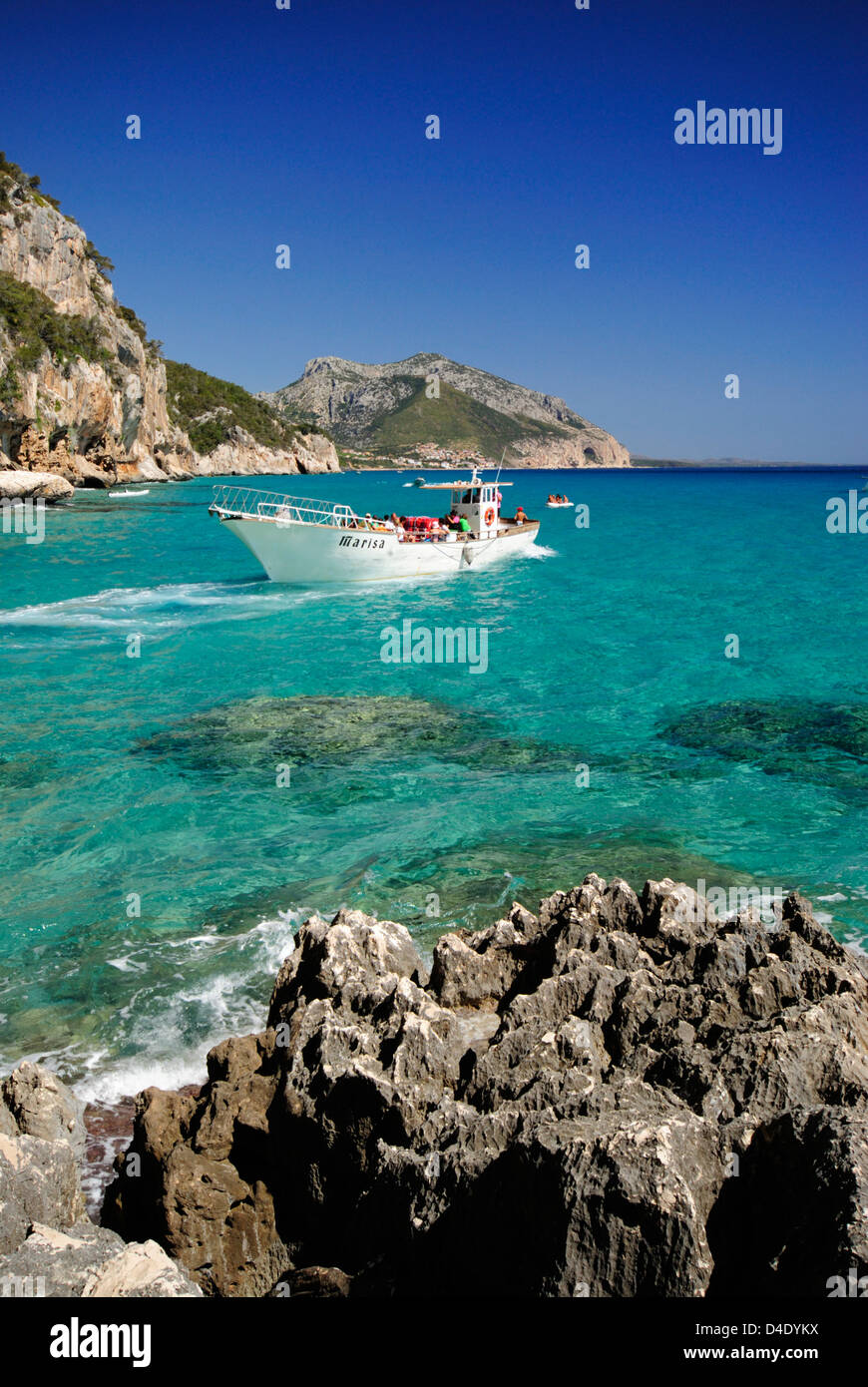 Ferryboat approaching the Bue Marino caves entrance and cliffs, in the Cala Gonone coast, Orosei gulf Sardinia, Italy Stock Photo