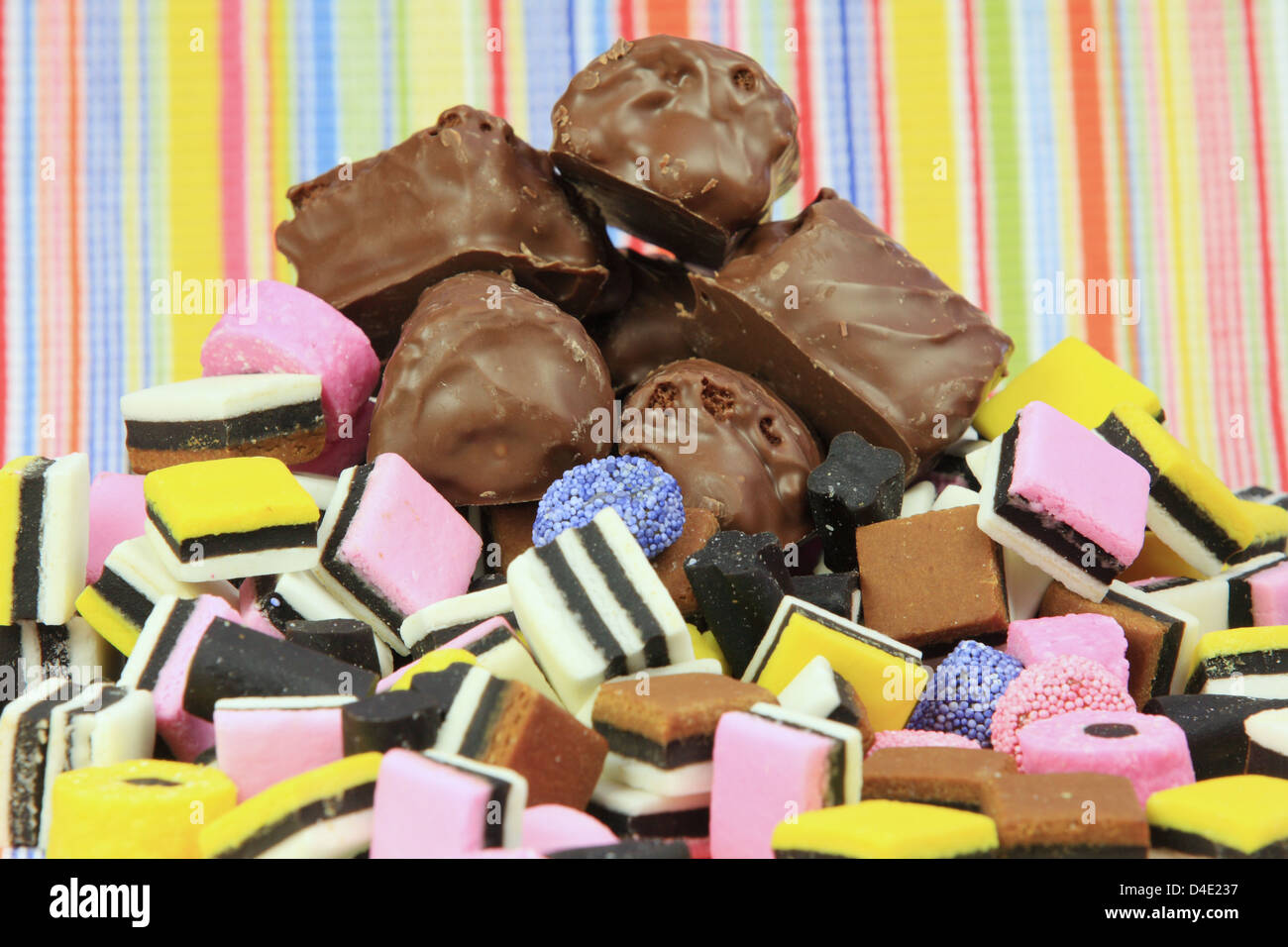 Some chocolate covered cakes on top of a stack of liquorice sweets