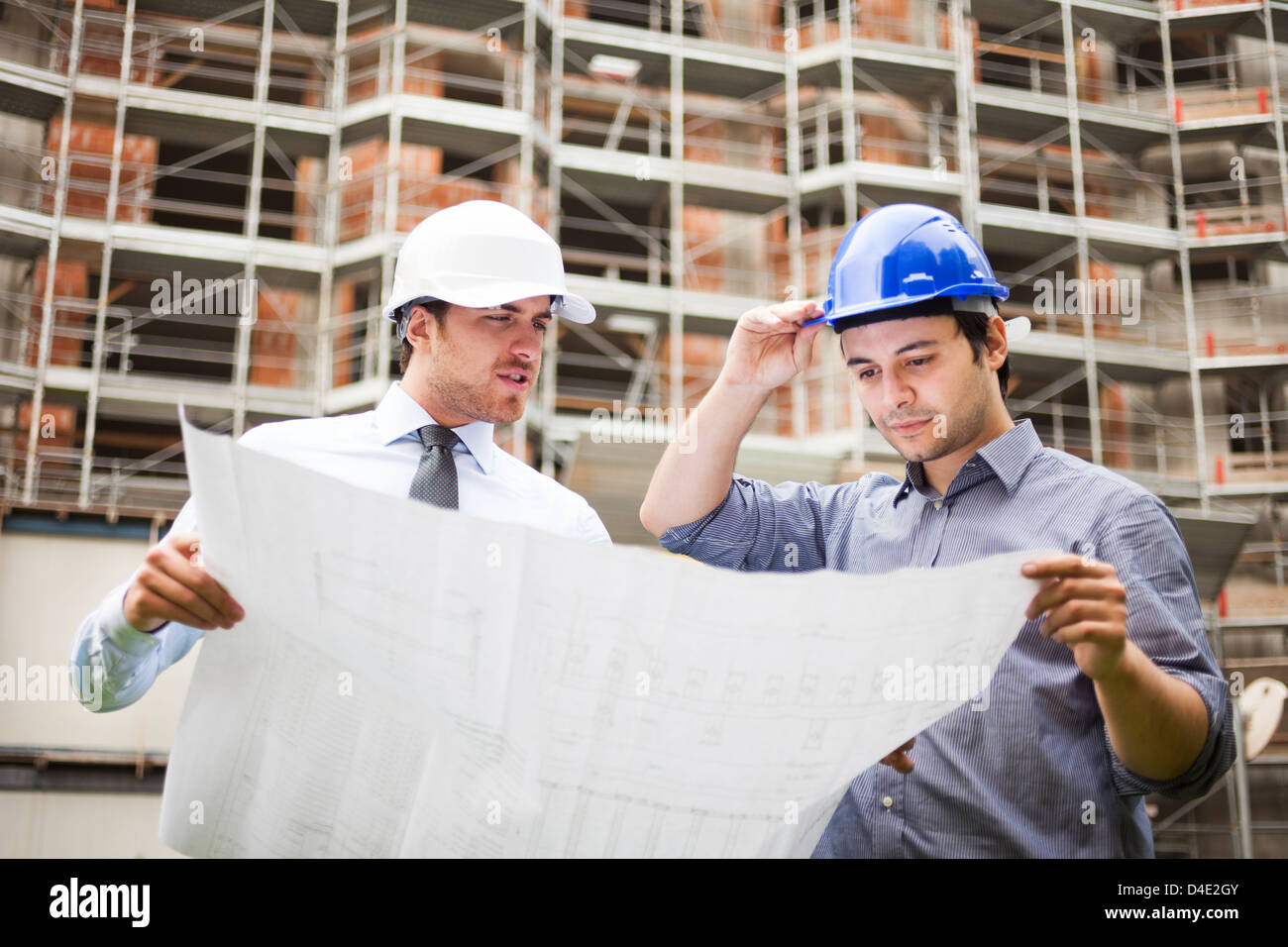 Architect explaining a drawing to the foreman Stock Photo - Alamy