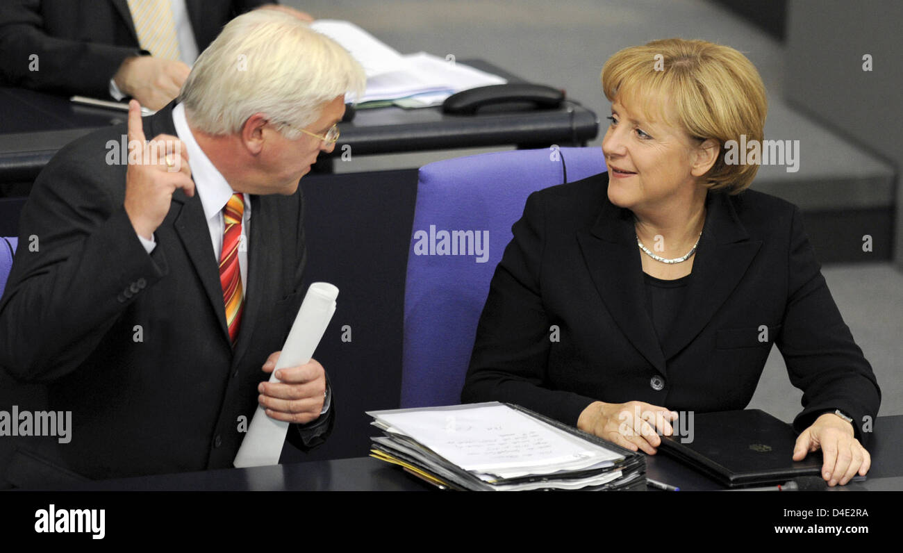 German Foreign Minister Frank-Walter Steinmeier (L) and Chancellor Angela Merkel talk during a special hearing of the German Bundestag in Berlin, Germany, 07 October 2008. German federal cabinet has agreed on the 14-month-extention of the Afghanistan mandate and an additional deployment of 1,000 soldiers, then numbering 4,500 in total. The decision has yet to be ratified by the Ger Stock Photo