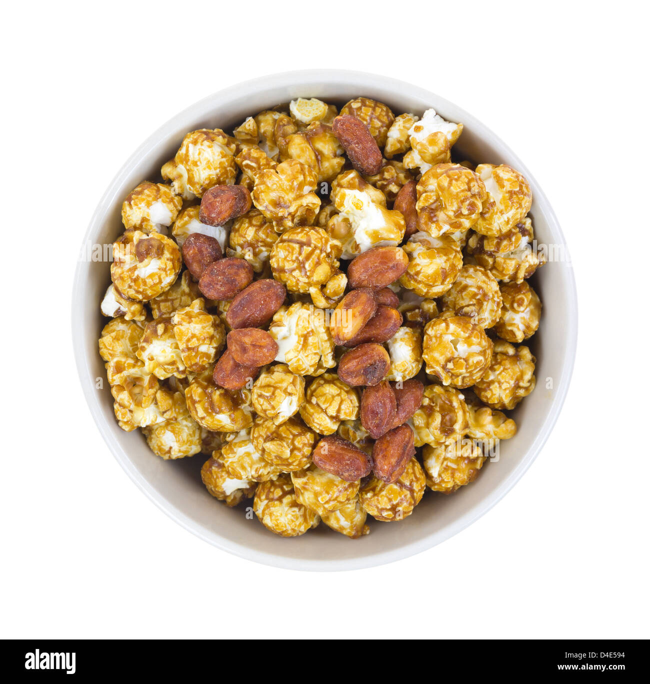 Top view of a bowl filled with caramel popcorn and peanuts on a white background. Stock Photo