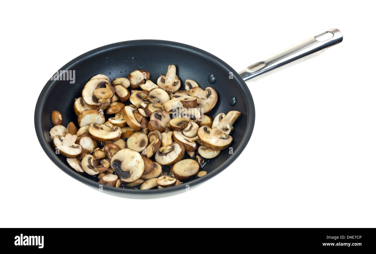 A large amount of sliced mushrooms cooking in olive oil in a large skillet on a white background
