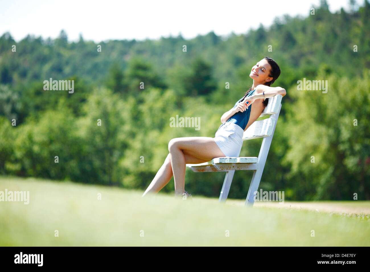 Young woman sitting on the bench in park Stock Photo - Alamy