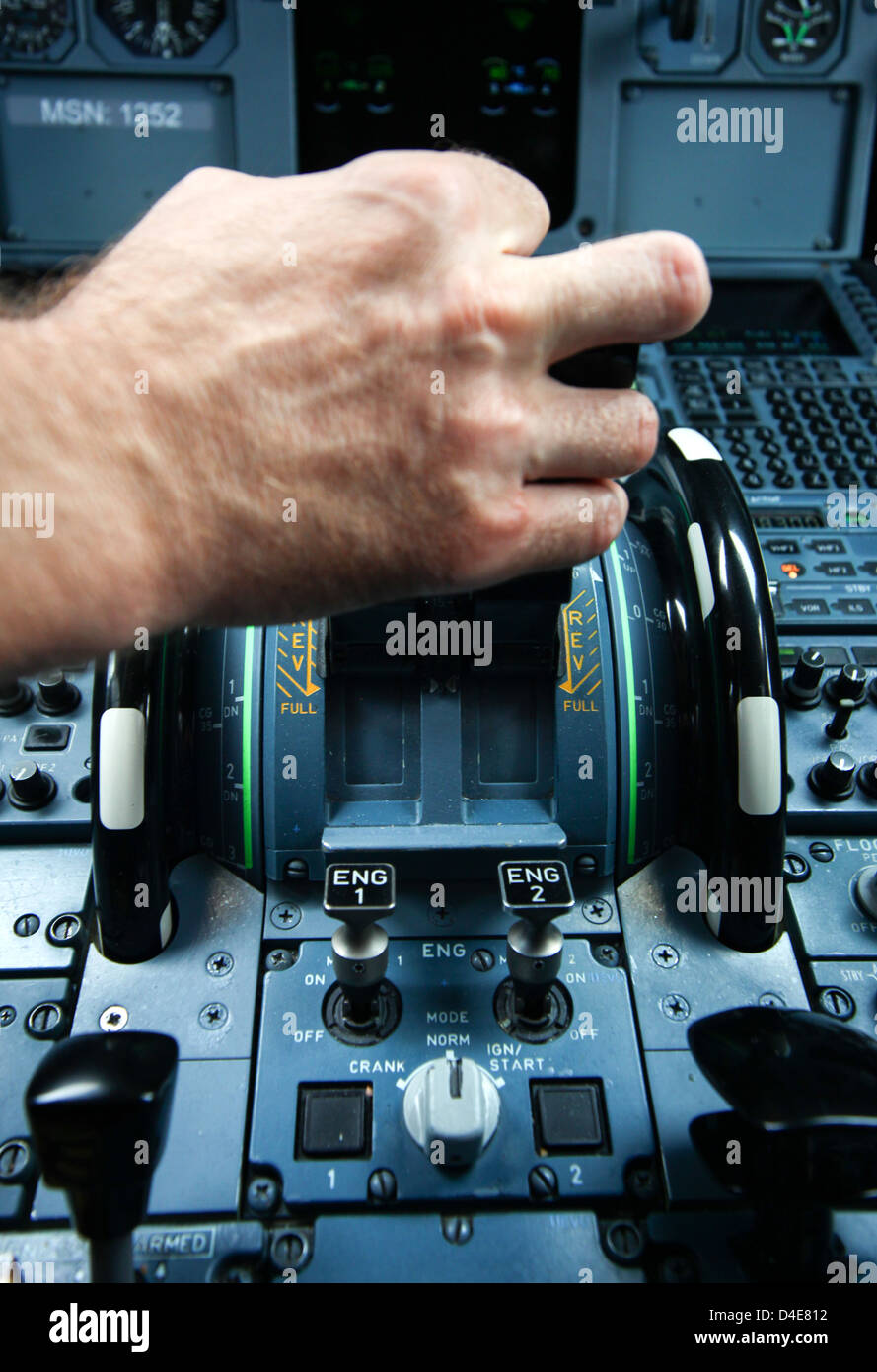 View of cockpit in air plain Airbus A320. Hand of pilot on engine controllers. Stock Photo