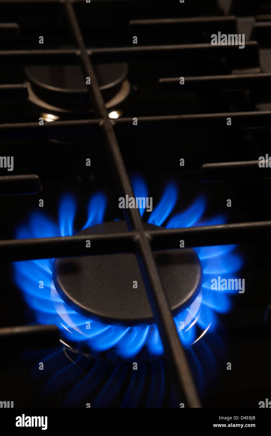 BLUE FLAME OF LIT GAS BURNER RING ON STOVE RANGE TOP Stock Photo