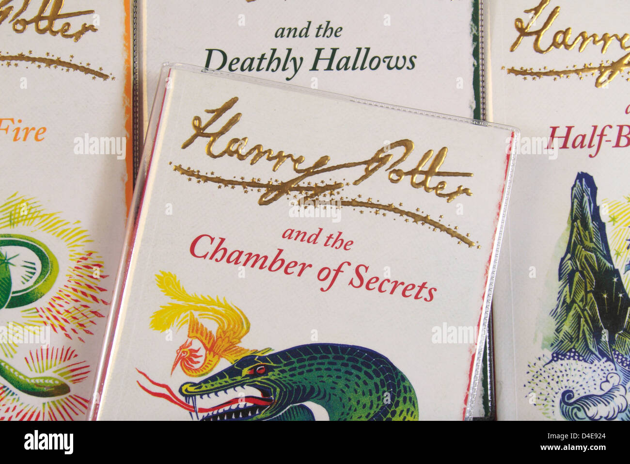 The book cover of "Harry Potter and the Chamber of Secrets" by JK Rowling sitting on other books in the series. Stock Photo