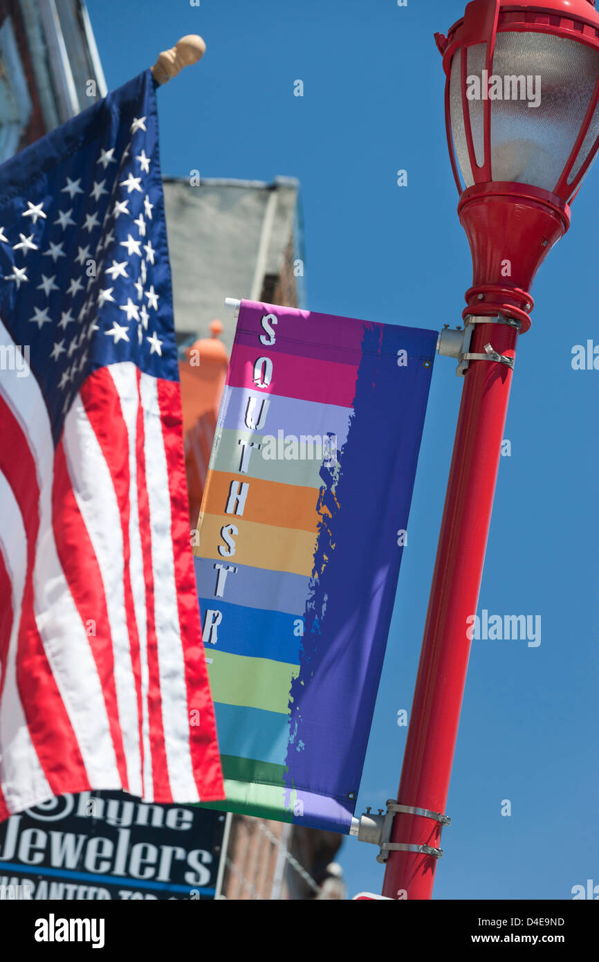 UNITED STATES FLAG AND BANNER ON RED LAMP POST SOUTH STREET DOWNTOWN PHILADELPHIA PENNSYLVANIA USA Stock Photo