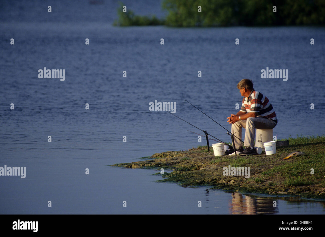 Man fishing for catfish and carp on Choke Canyon Lake, Tilden Texas Stock Photo