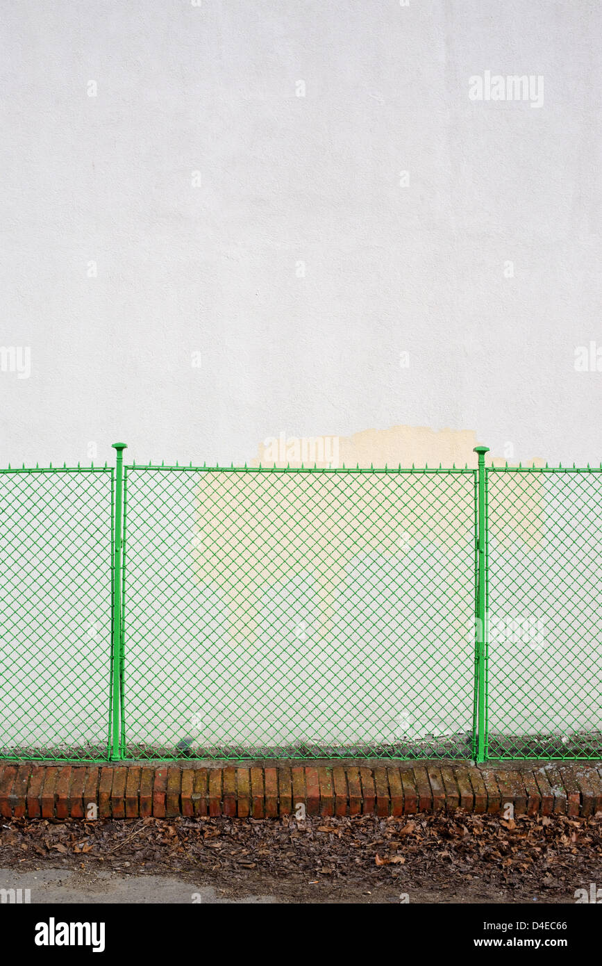Green metal grid fence, urban scenery background. Stock Photo