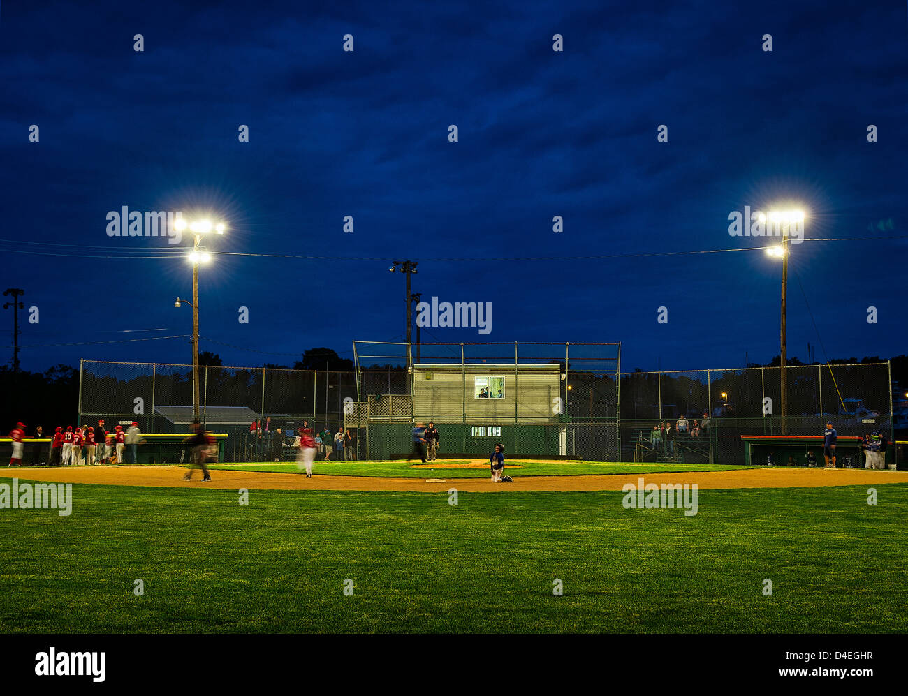 Little League baseball game at night. Stock Photo