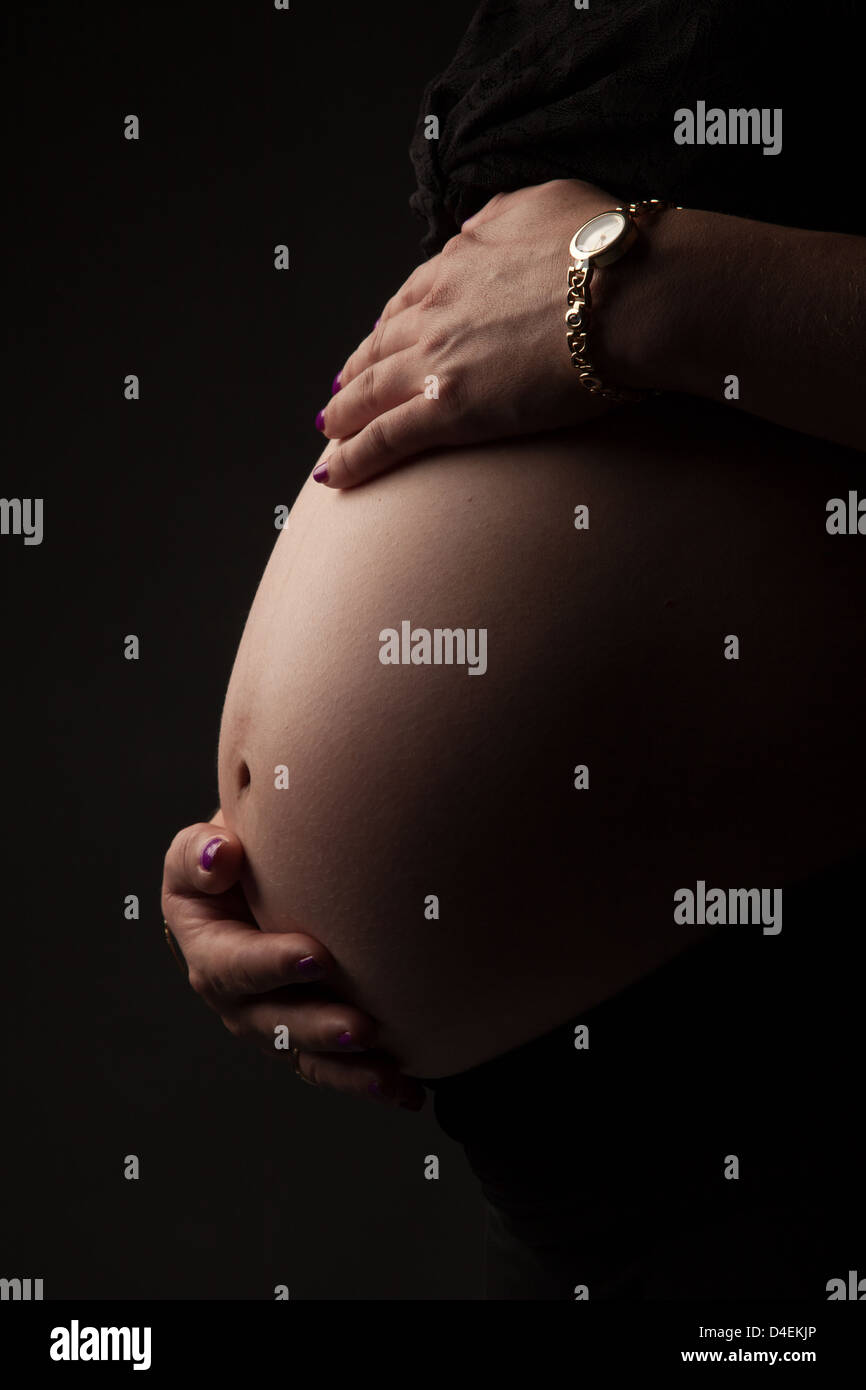 Pregnant woman holding her belly Stock Photo - Alamy