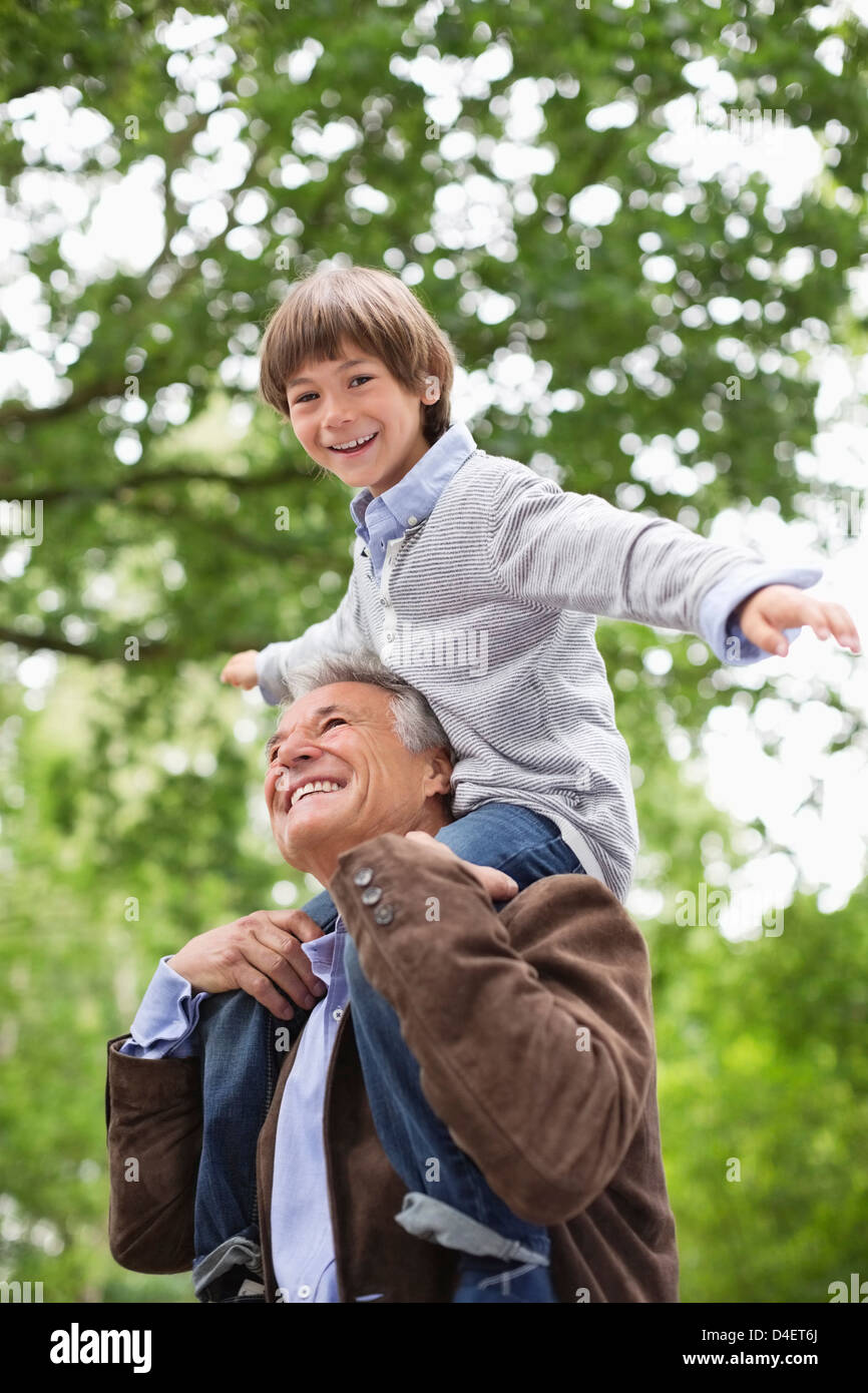 Man carrying grandson on shoulders outdoors Stock Photo