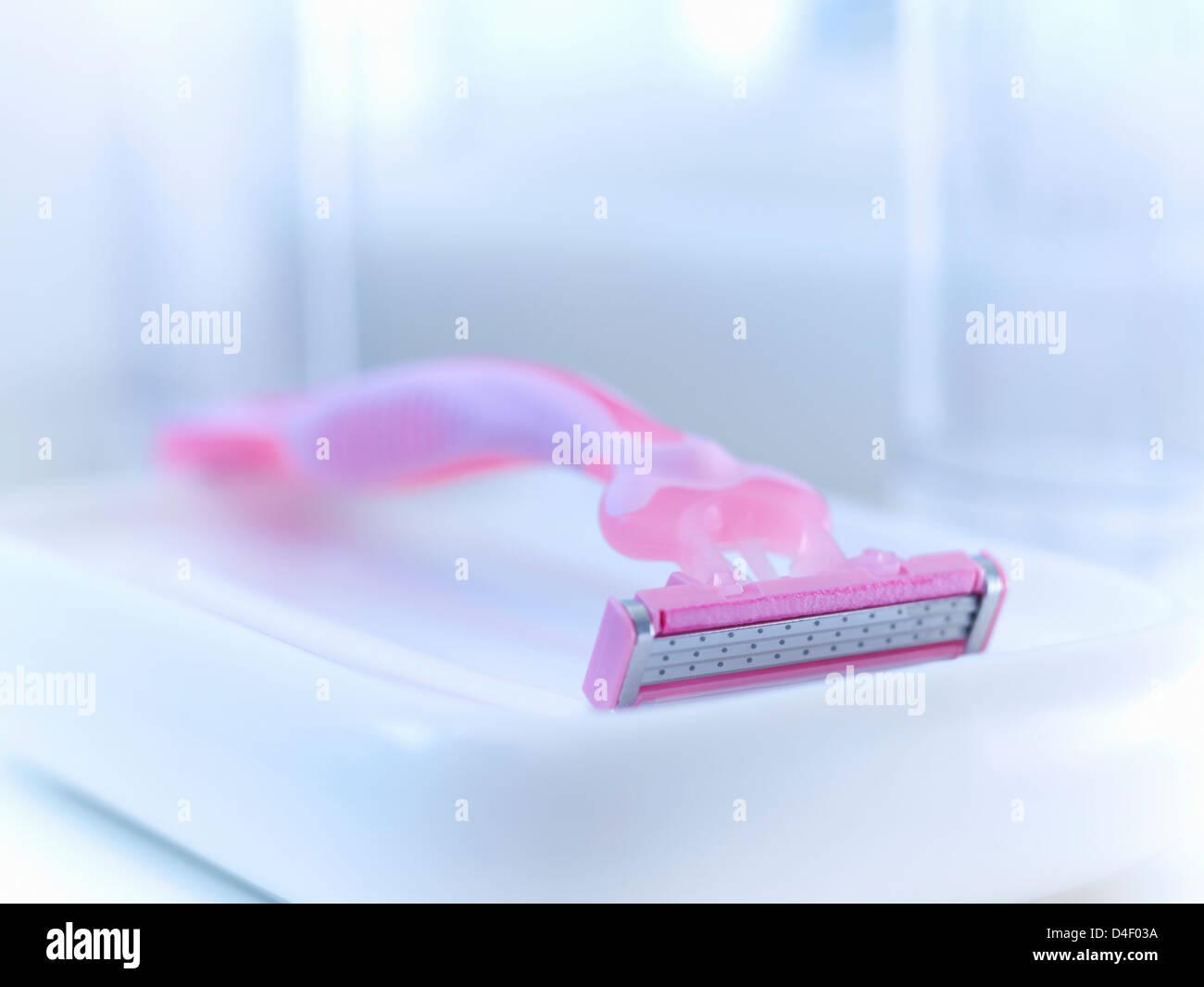 Close up of pink razor in bathroom Stock Photo
