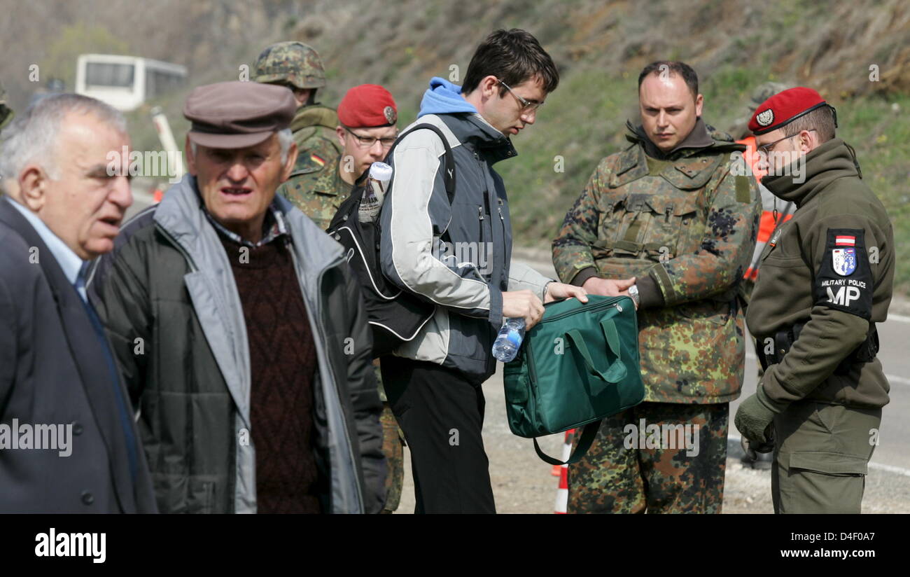Soldiers of German Bundeswehr and Austrian Military Police inspect a ...