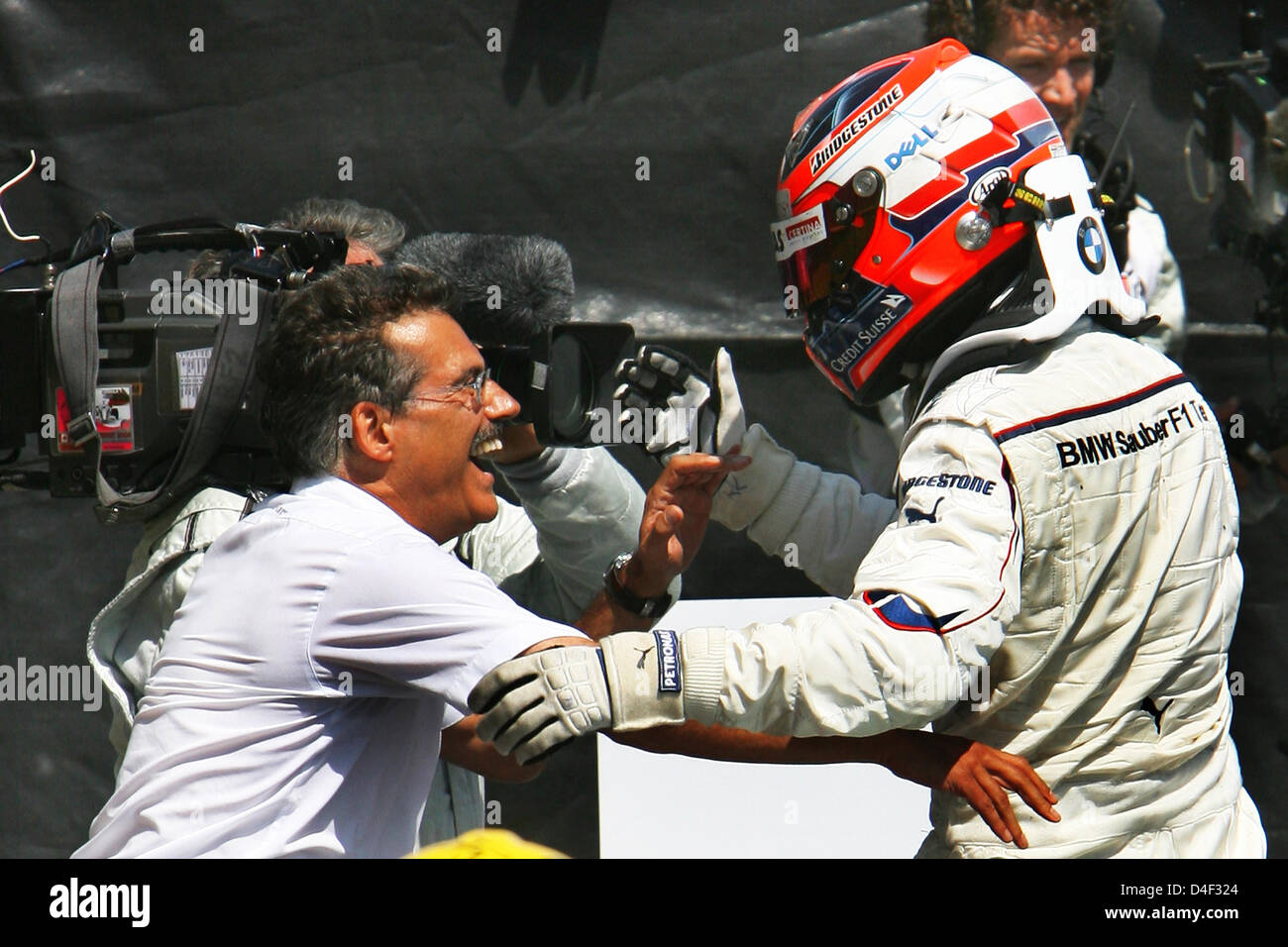 Polish Formula One driver Robert Kubica of BMW Sauber (R) hugs German