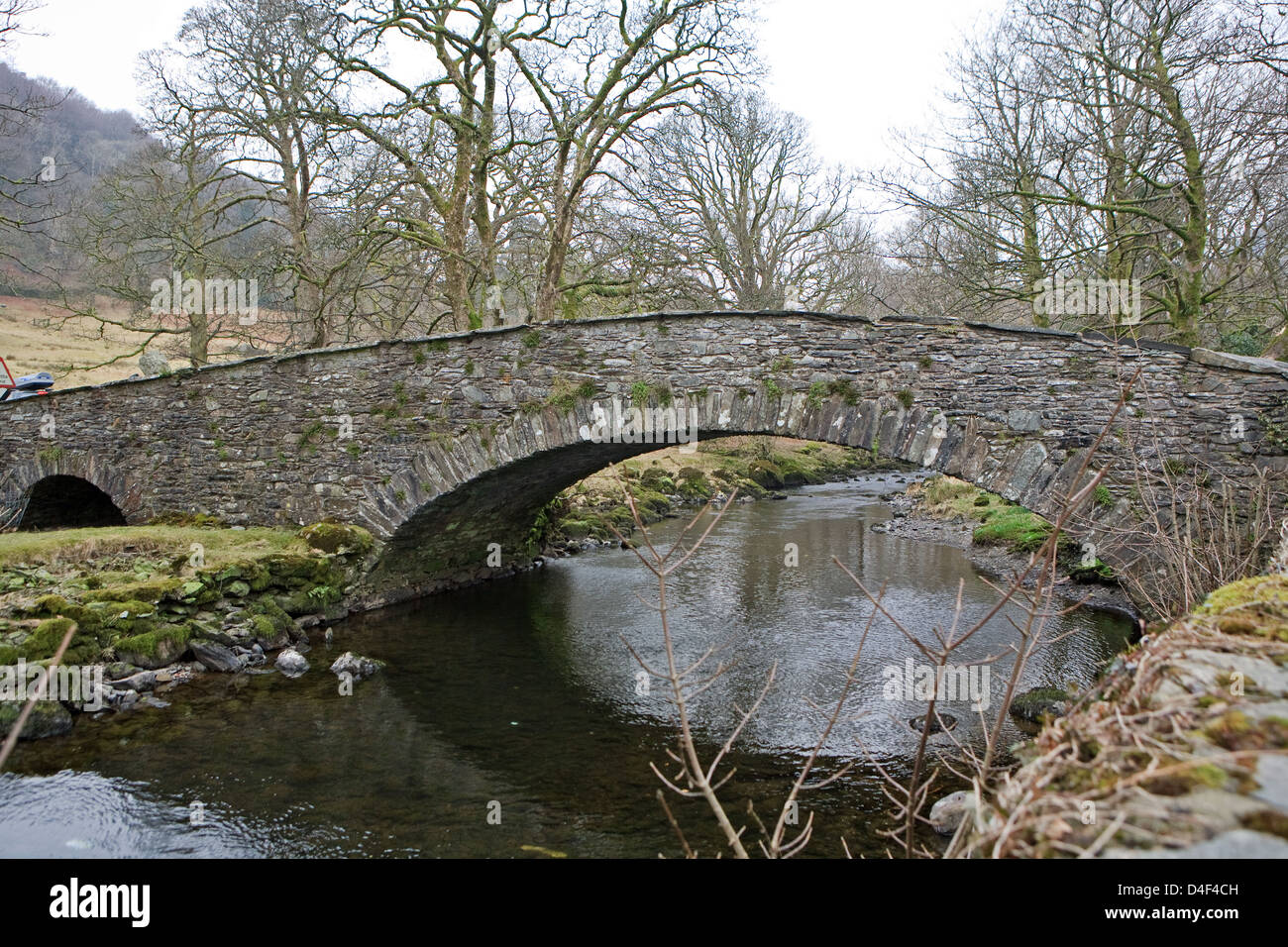 A stone bridge across a stream in the Lake District England Stock Photo ...
