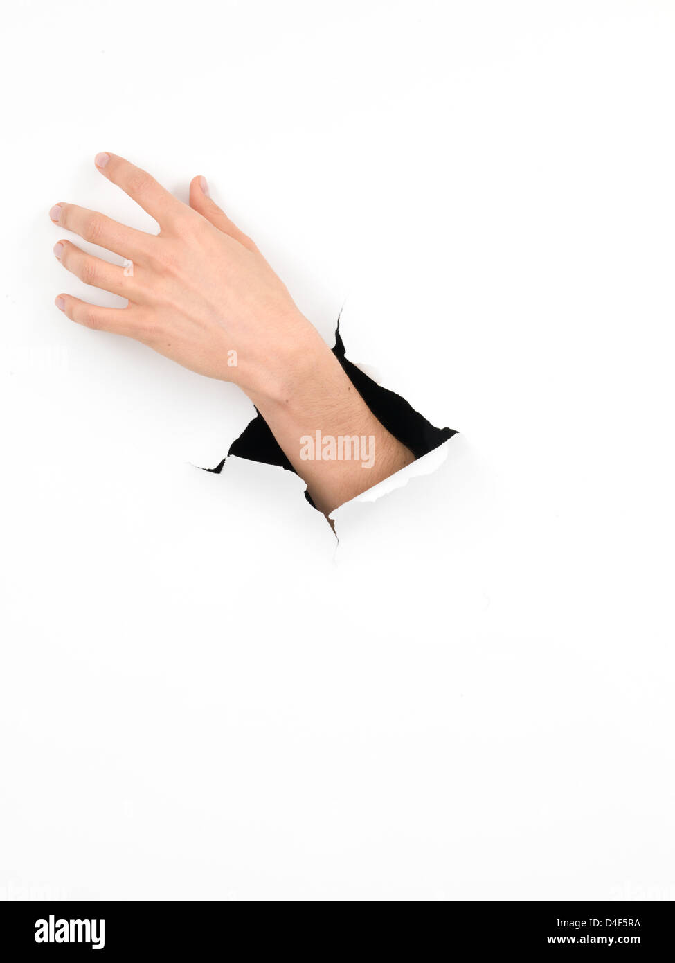 close-up of female hand coming out from a hole in a white paper, reaching out for something, isolated Stock Photo