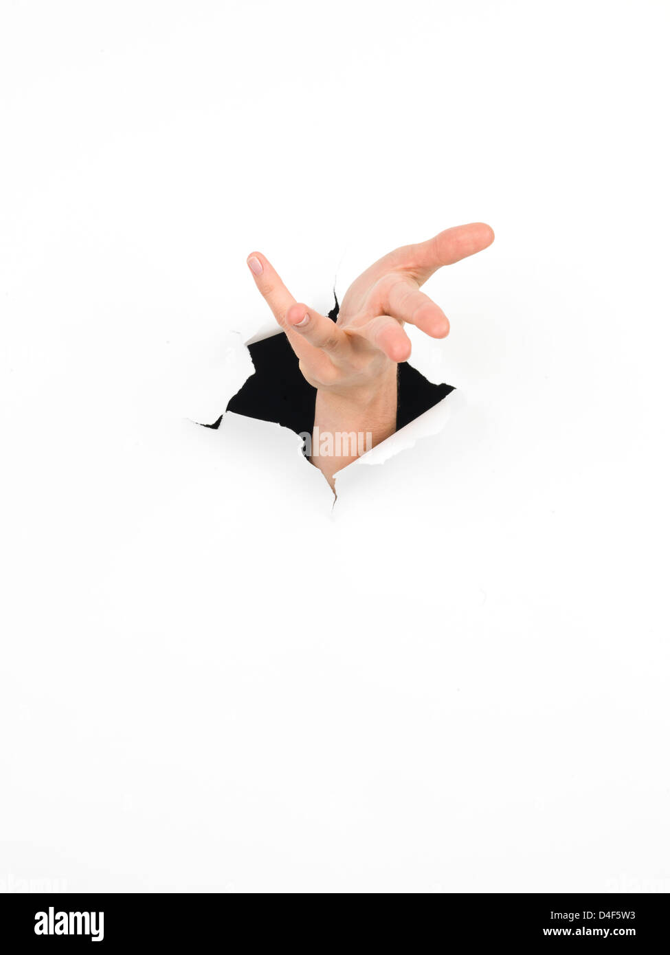 closeup of female hand coming out from a hole in a paper, with a