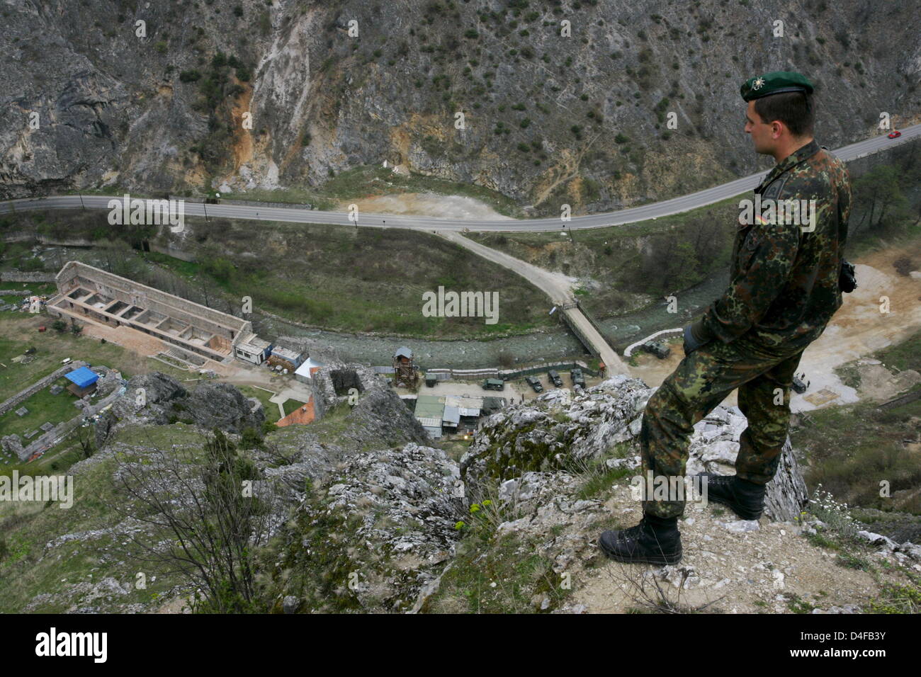 A soldier of the German Bundeswehr monitors the area around the ...