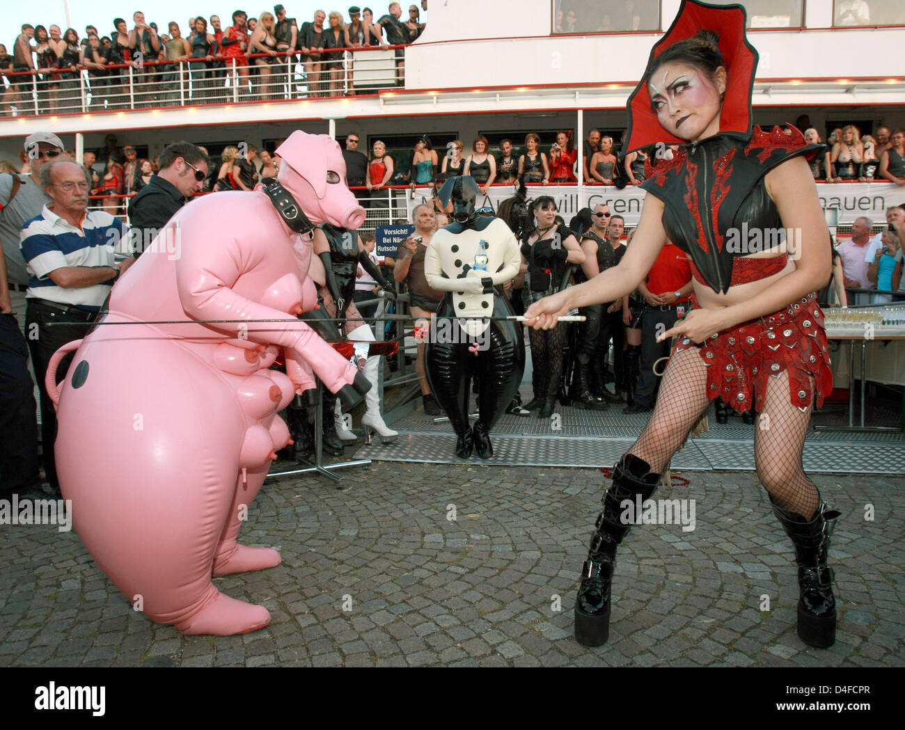 Hundreds of sado-maso people watch persons dressed as submissive pig (L)  and dominatrix (R) on ship 'MS Schwaben' in the harbour of Konstanz,  Germany, 28 June 2008. Some 800 sado-maso people partied