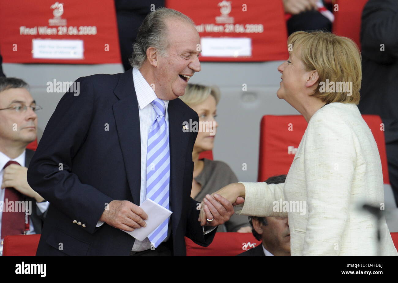 Spanish King Juan Carlos (l) welcomes German Chancellor Angela Merkel during the UEFA EURO 2008 final match between Germany and Spain at the Ernst Happel stadium in Vienna, Austria, 29 June 2008. Photo: Peter Kneffel dpa +++###dpa###+++ Stock Photo