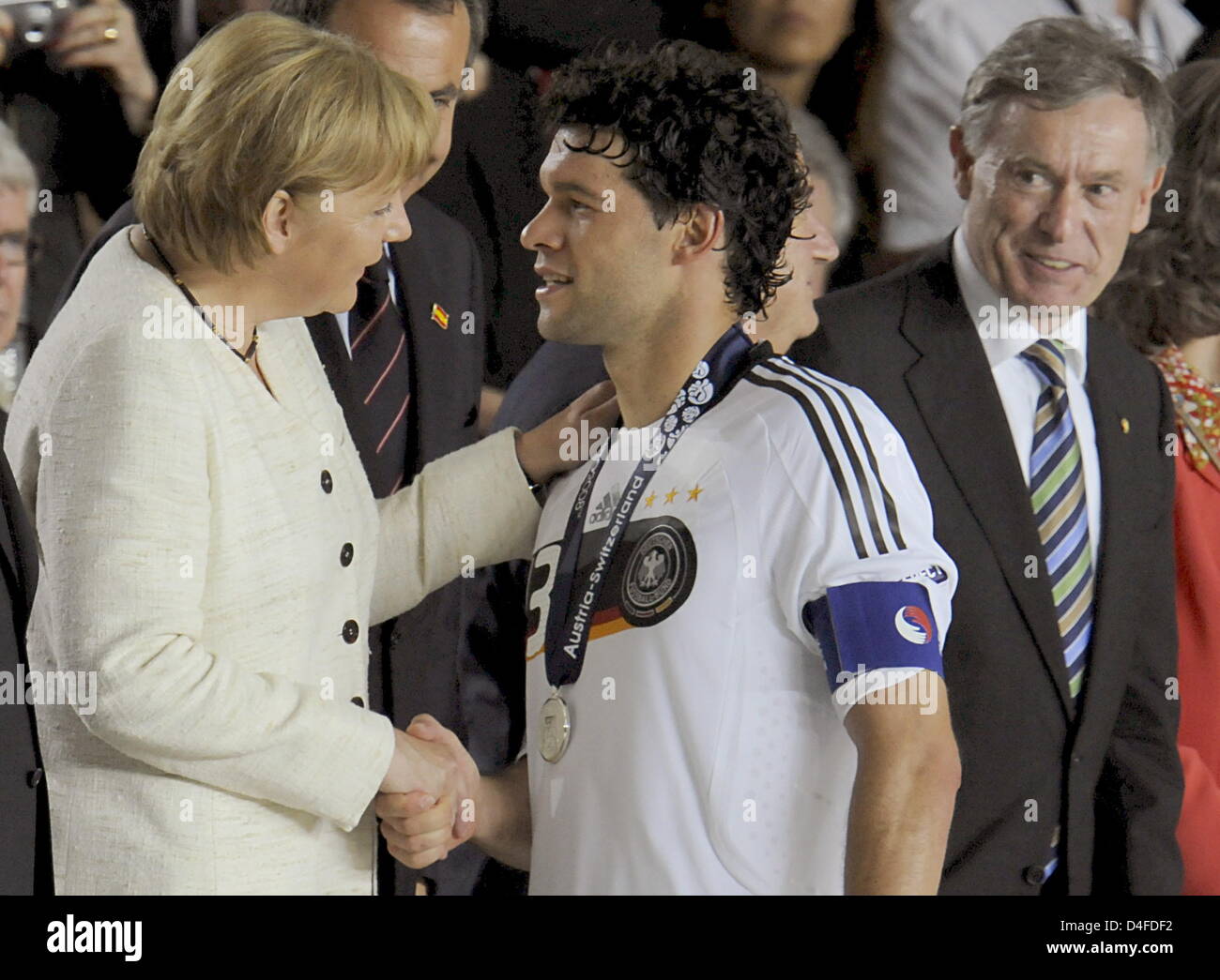 German Chancellor Angela Merkel (l) hugs German soccer player Michael Ballack at the end of the UEFA EURO 2008 final match between Germany and Spain at the Ernst Happel stadium in Vienna, Austria, 29 June 2008. Looking on is German President Horst Koehler. Spain won the match by 1:0. Photo: Peter Kneffel dpa +++###dpa###+++ Stock Photo