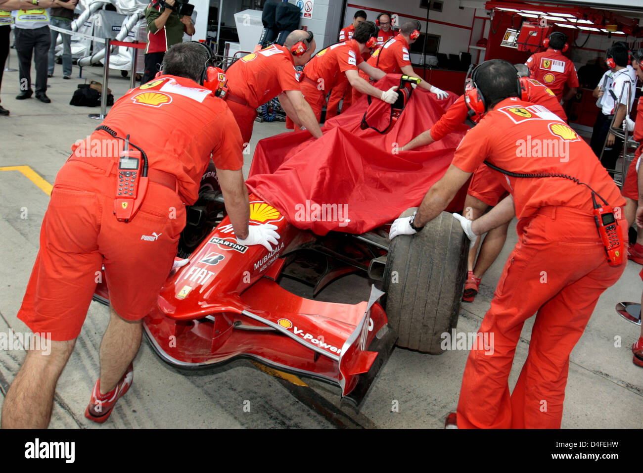 Mechanics push the car of Brazilian Formula One driver Felipe Massa of ...