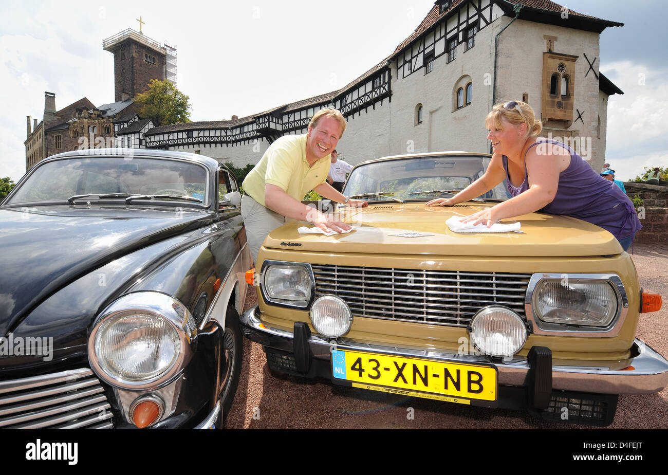 Dutch Carlo Kuit (L) and Anouck Kievit clean their 1980 'Wartburg 335w' in front of the historical Wartburg in Eisenach, Germany, 01 August 2008. A 1965 'Wartburg 311' model is pictured next to them (L). The cars were manufactured in GDR times at the 'VEB Automobile Works Eisenach (AWE)'. The 9th international Wartburg meeting takes place from 01 till 03 August 2008 in Eisenach inc Stock Photo