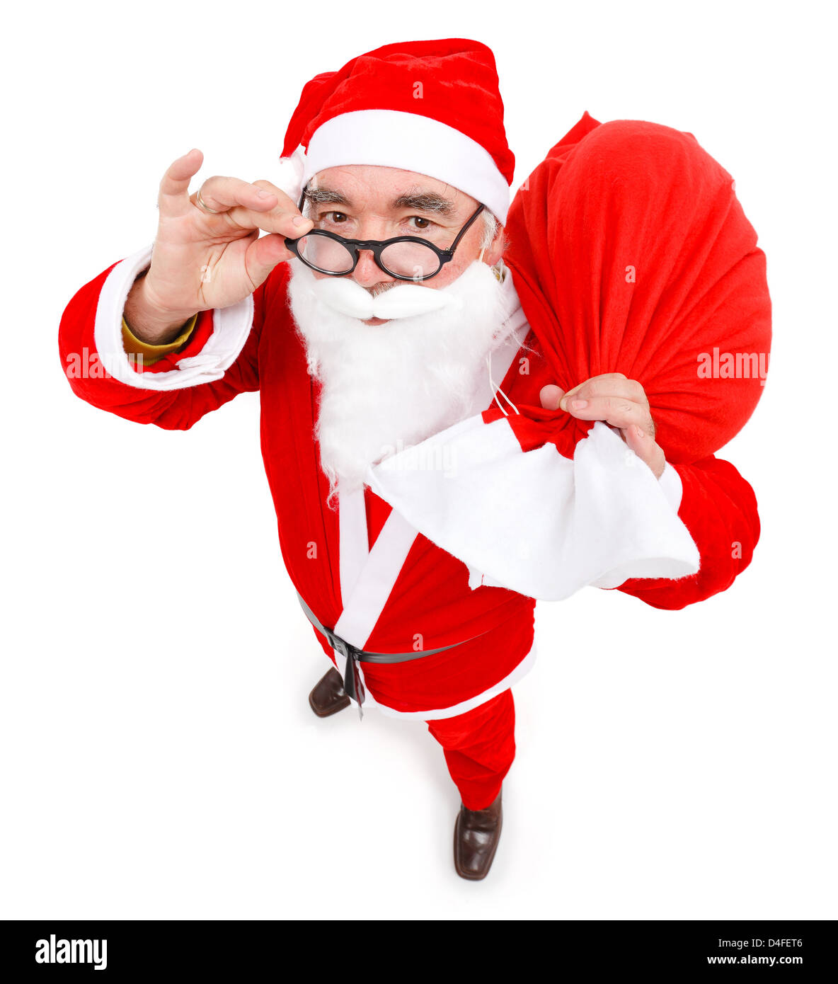 Senior man wearing Santa Claus uniform, holding a full bag, looking up Stock Photo