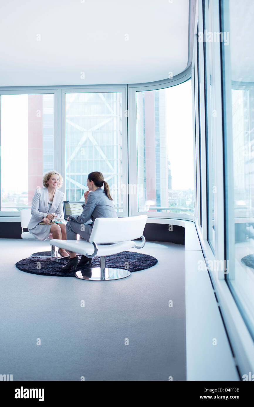 Businesswomen talking in office lobby Stock Photo - Alamy