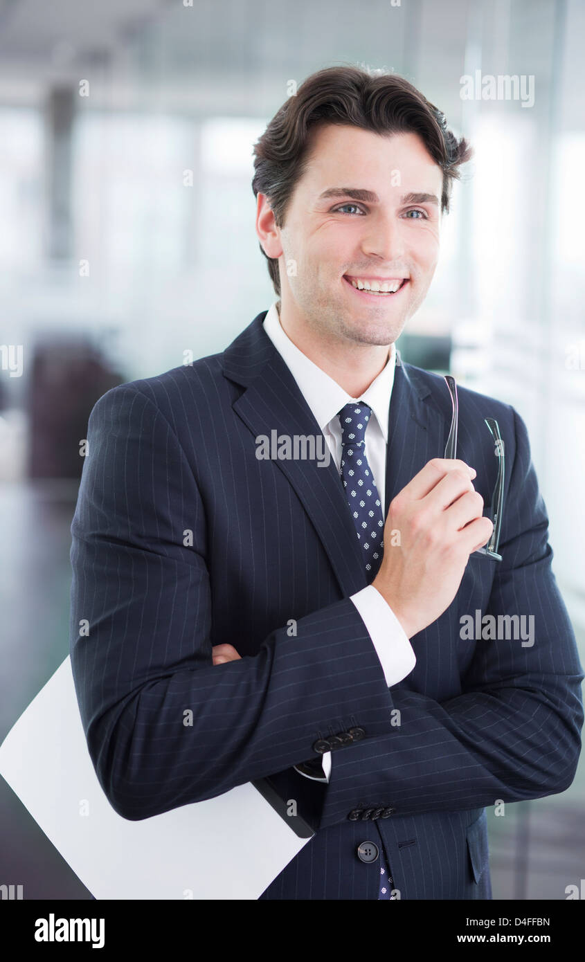 Businessman smiling in office hallway Stock Photo