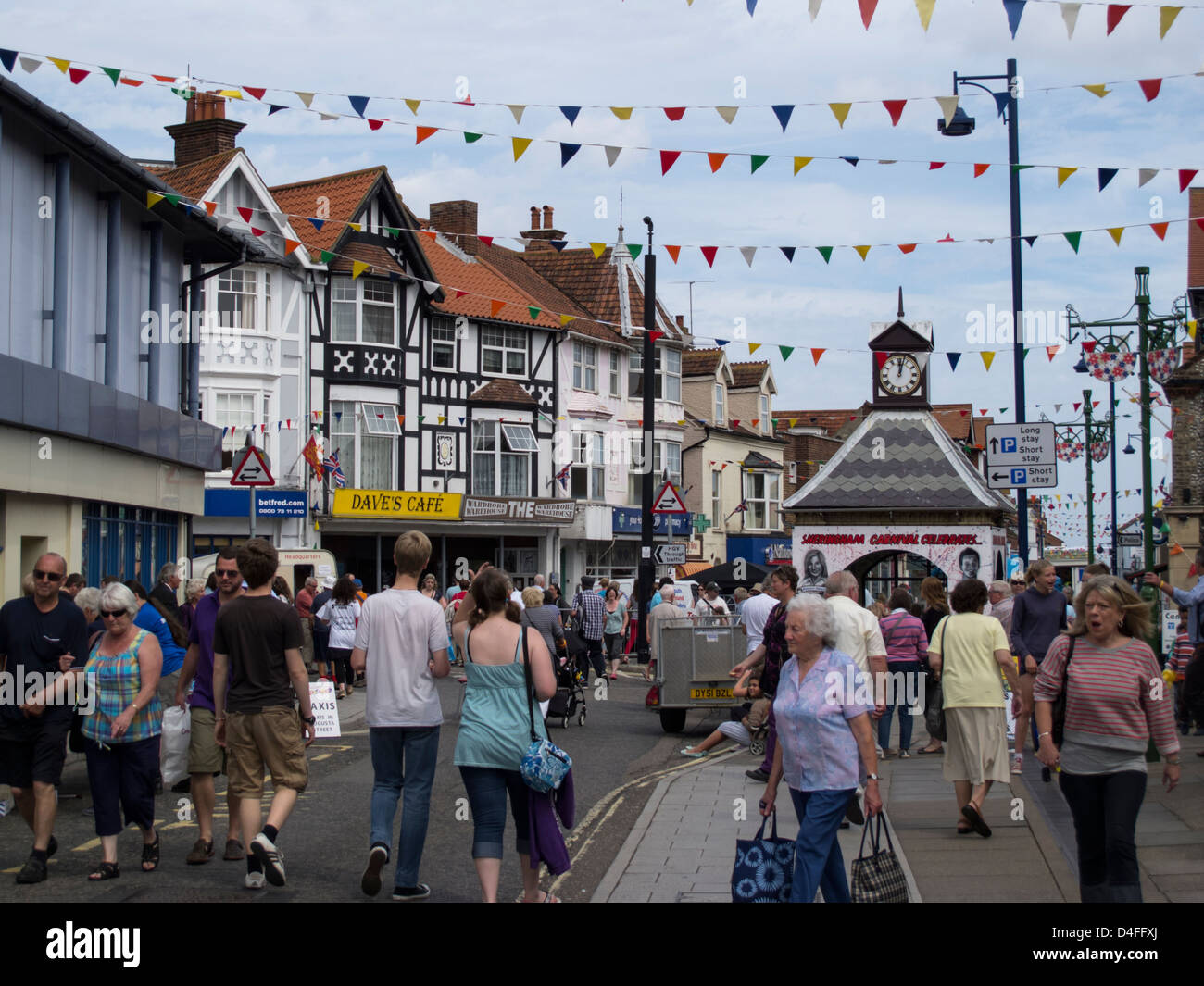 Norfolk seaside town of Sheringham high street on carnival day with crowds of people East Anglia