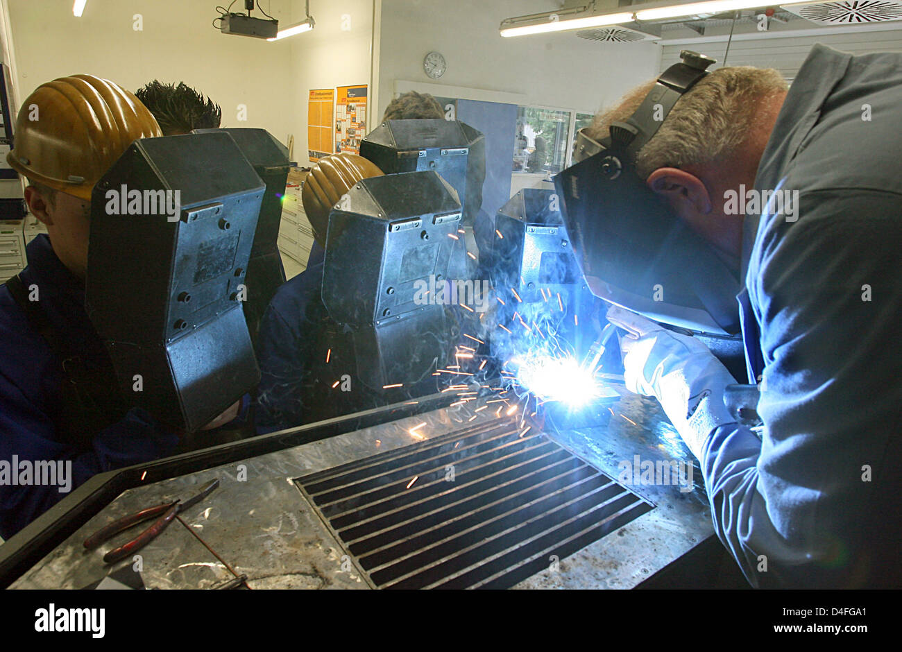 Trainees practice gas-shielded welding at Mercedes-Benz' vocational training centre in Esslingen-Bruehl, Germany, 6 July 2008. By 31 December 2007 some 1,110 young people were trained in technical and commercial vocations and BA courses, among them 110 women. More than 50 teachers and master craftmen teach at the centre. Photo: Norbert Foersterling Stock Photo